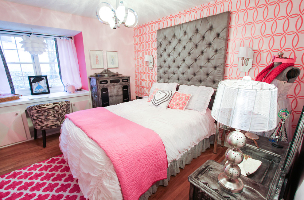 Modelo de dormitorio retro pequeño con paredes rosas y suelo de madera en tonos medios