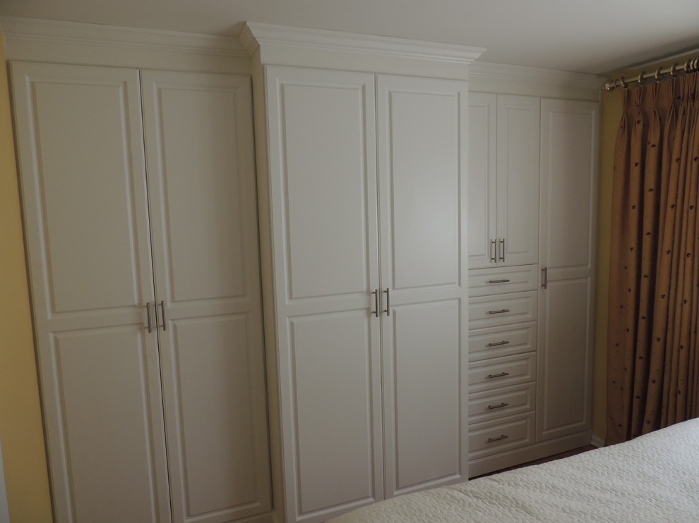 Photo of a medium sized traditional master bedroom in Philadelphia with yellow walls and dark hardwood flooring.