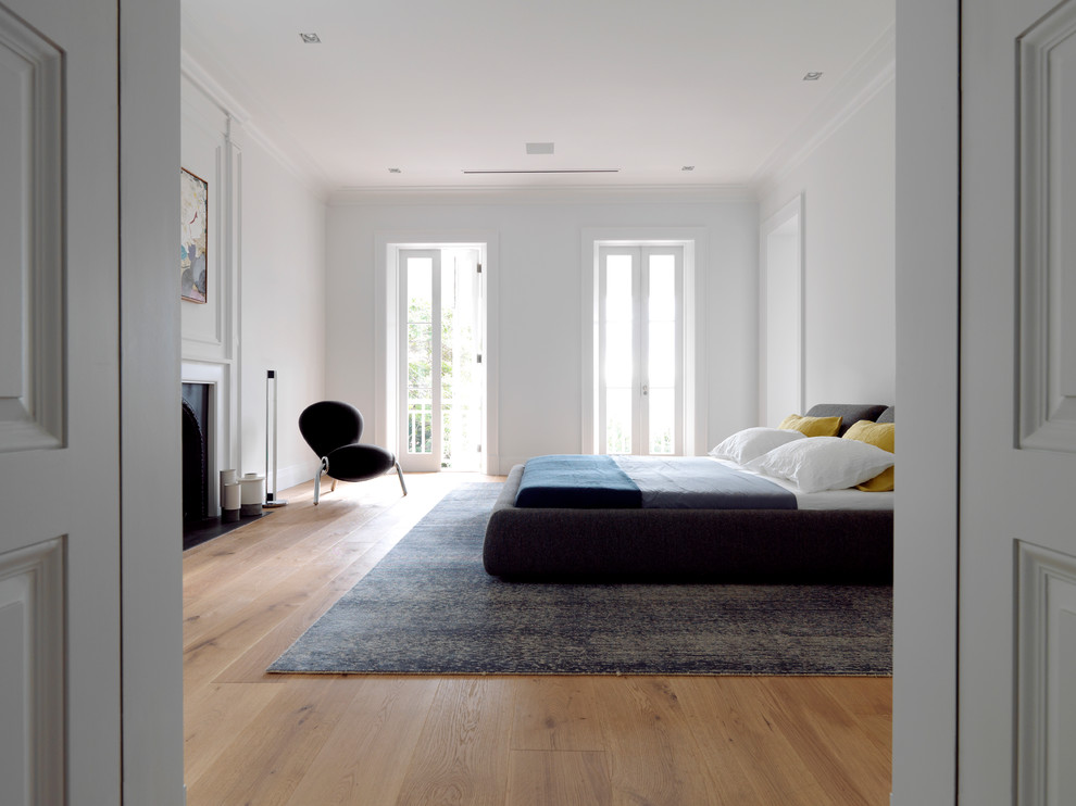Mittelgroßes Klassisches Schlafzimmer mit weißer Wandfarbe und braunem Holzboden in Sydney