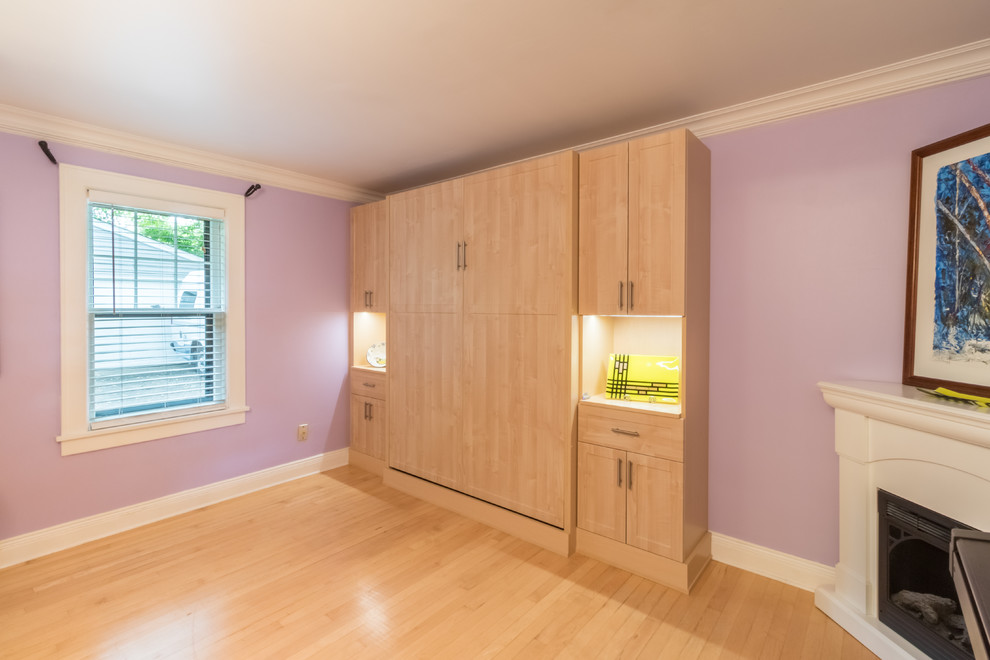 Aménagement d'une chambre d'amis classique de taille moyenne avec un mur rose, parquet clair et une cheminée d'angle.
