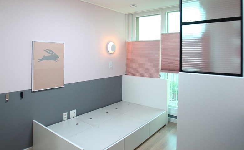 Immagine di una camera degli ospiti minimalista di medie dimensioni con pareti rosa e pavimento in bambù