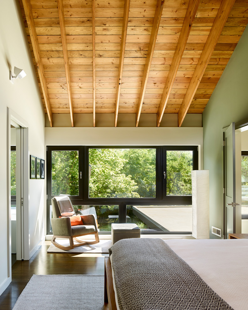 Imagen de dormitorio principal contemporáneo de tamaño medio con paredes blancas, suelo de madera en tonos medios y suelo marrón