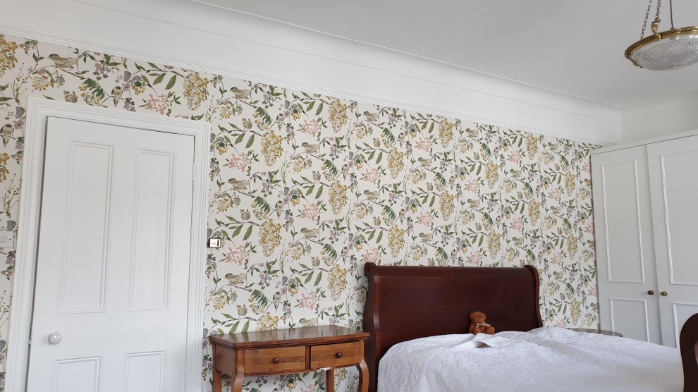 Großes Klassisches Hauptschlafzimmer mit grüner Wandfarbe, Teppichboden, Kamin, Kaminumrandung aus Stein, grünem Boden, eingelassener Decke und Tapetenwänden in London