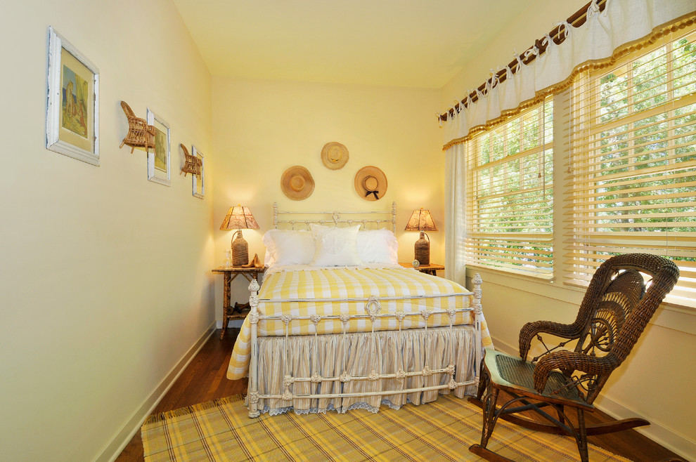 Immagine di una camera da letto country con pareti gialle