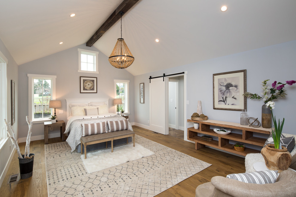 Large farmhouse master bedroom in San Francisco with grey walls, medium hardwood flooring, brown floors and no fireplace.