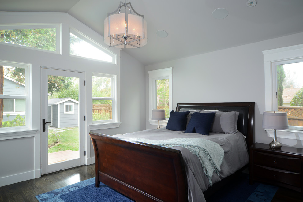 Modelo de dormitorio de estilo americano con paredes grises y suelo de madera en tonos medios