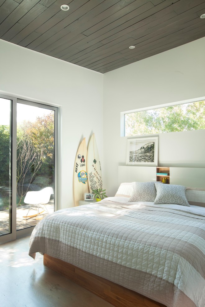 Modelo de dormitorio principal contemporáneo con paredes blancas y suelo de madera en tonos medios