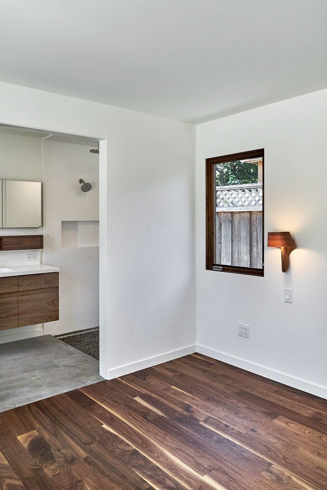 Idee per una piccola camera matrimoniale moderna con pareti grigie, pavimento in legno massello medio e pavimento marrone