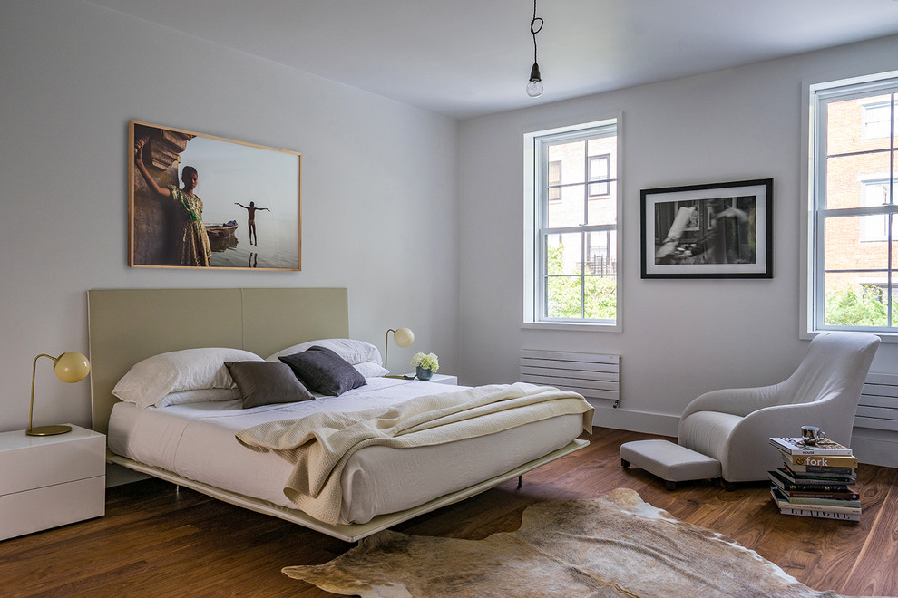 Cette photo montre une chambre chic avec un sol en bois brun.