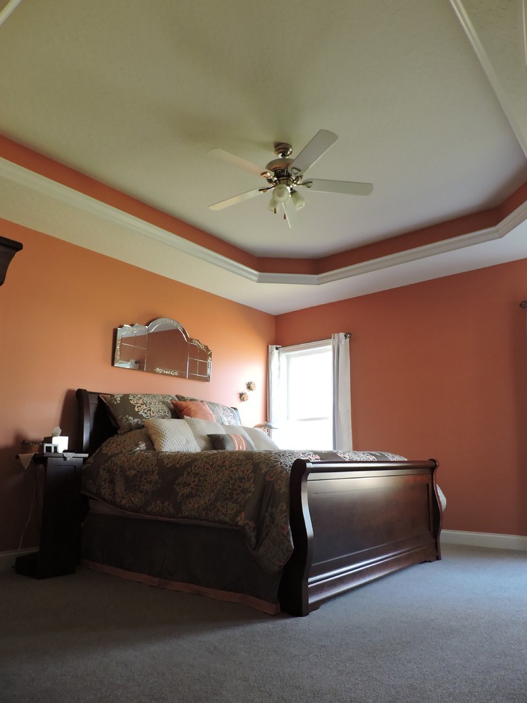 Пример оригинального дизайна: большая хозяйская спальня в современном стиле с оранжевыми стенами и ковровым покрытием