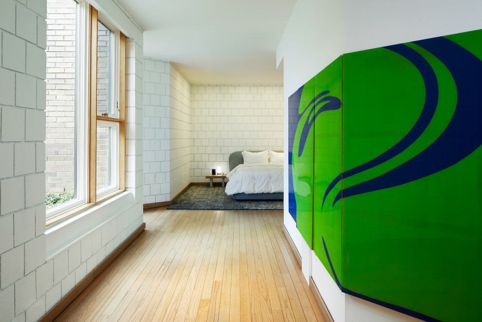 Ejemplo de dormitorio principal moderno grande con paredes blancas, suelo de madera clara y suelo beige