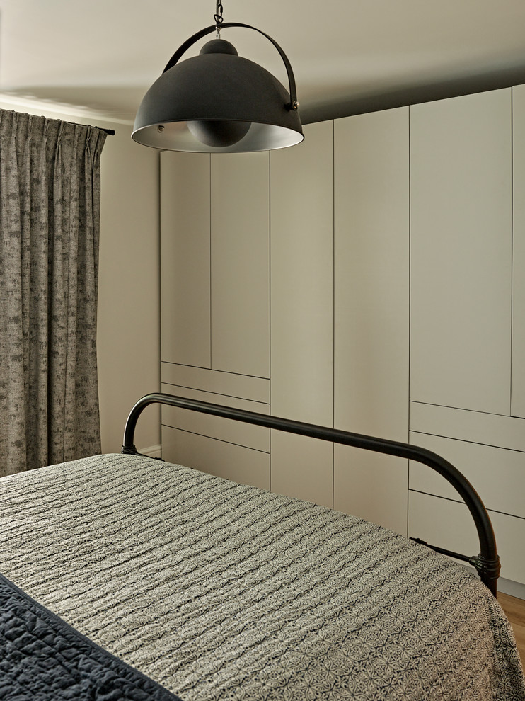 Mittelgroßes Modernes Hauptschlafzimmer mit blauer Wandfarbe und hellem Holzboden in London