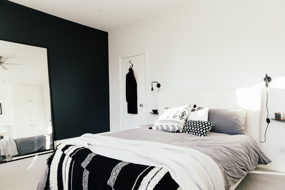 Diseño de dormitorio principal nórdico grande con paredes negras, moqueta, todas las chimeneas, marco de chimenea de madera y suelo gris