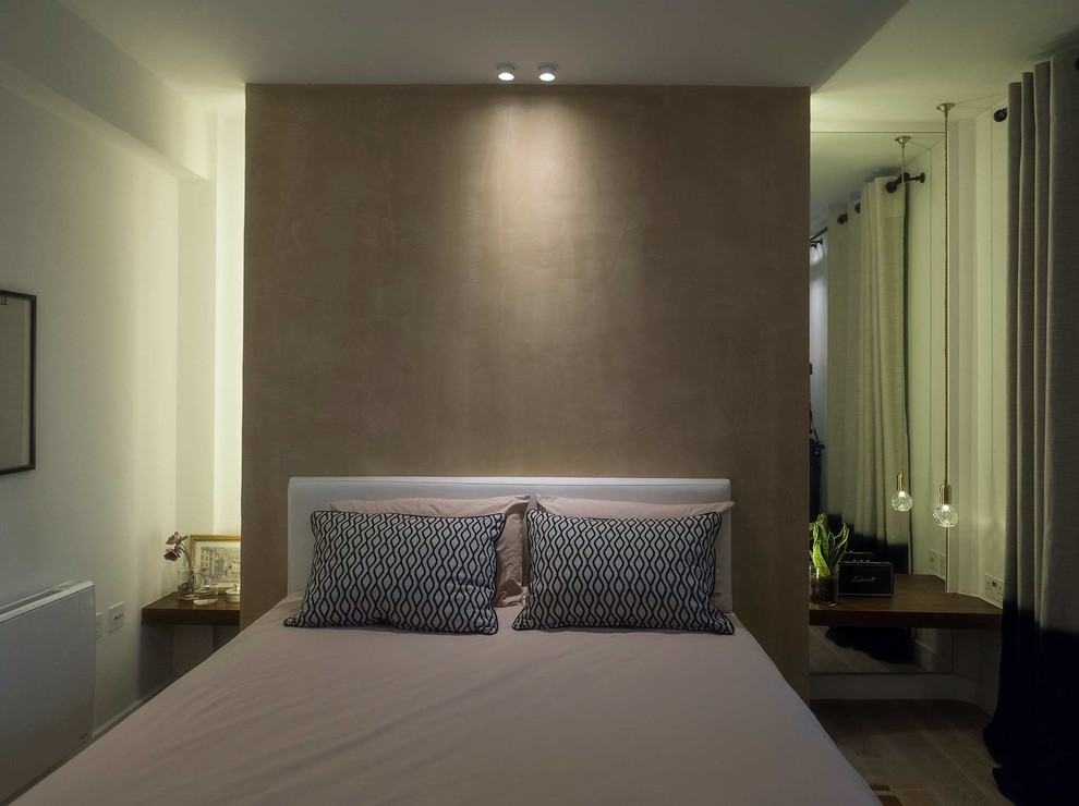 Diseño de dormitorio principal moderno de tamaño medio con paredes beige, suelo de madera en tonos medios y suelo beige