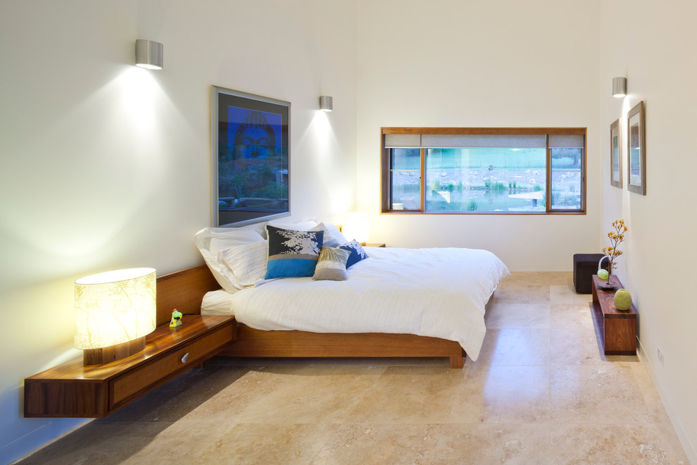 Стильный дизайн: спальня в скандинавском стиле с белыми стенами и полом из травертина - последний тренд