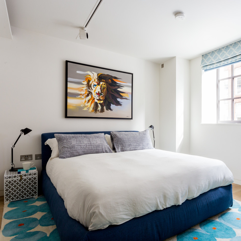 Immagine di una camera da letto contemporanea di medie dimensioni con pareti bianche, parquet chiaro, pavimento beige e nessun camino