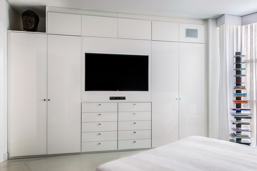 Modelo de dormitorio principal actual de tamaño medio con paredes blancas y suelo de cemento