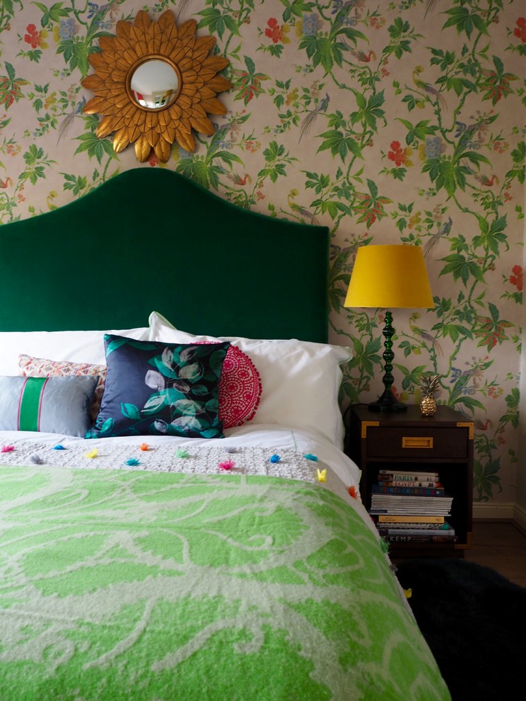 Modelo de habitación de invitados bohemia pequeña con paredes multicolor, suelo laminado y suelo marrón
