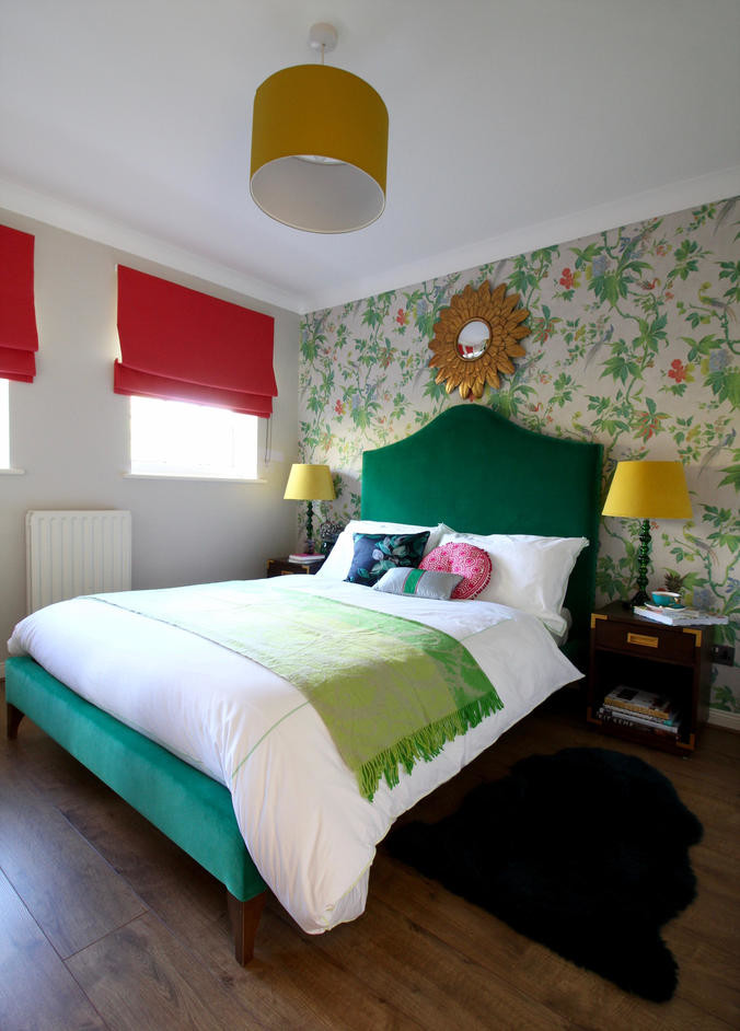 Esempio di una piccola camera degli ospiti boho chic con pareti multicolore, pavimento in laminato e pavimento marrone