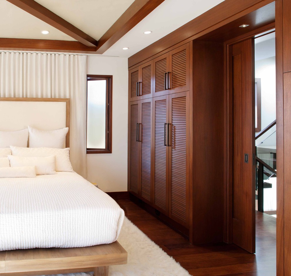 Modelo de dormitorio principal contemporáneo sin chimenea con paredes blancas, suelo de madera oscura y suelo marrón
