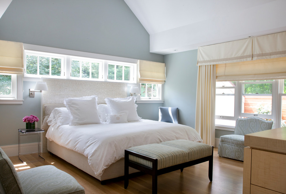 Diseño de dormitorio principal costero grande con paredes azules y suelo de madera clara