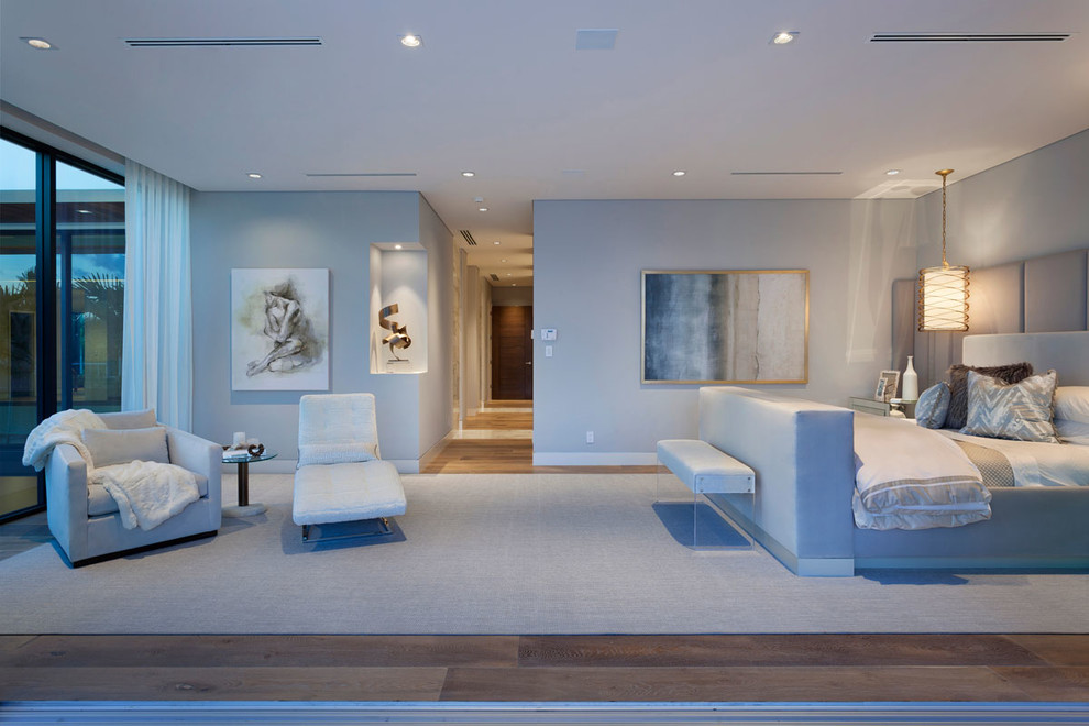 Großes Modernes Hauptschlafzimmer ohne Kamin mit grauer Wandfarbe und braunem Holzboden in Miami