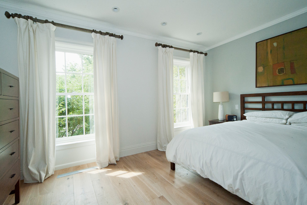 Foto de habitación de invitados clásica renovada grande sin chimenea con paredes grises, suelo de madera clara y suelo beige