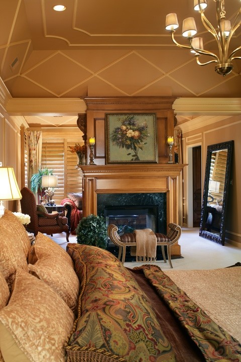 Aménagement d'une très grande chambre classique avec un mur marron, une cheminée double-face et un manteau de cheminée en pierre.