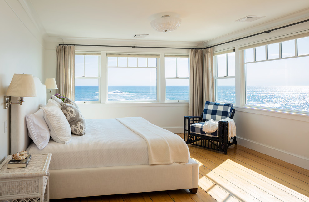 Immagine di una camera da letto stile marino con pareti bianche, pavimento in legno massello medio e pavimento beige