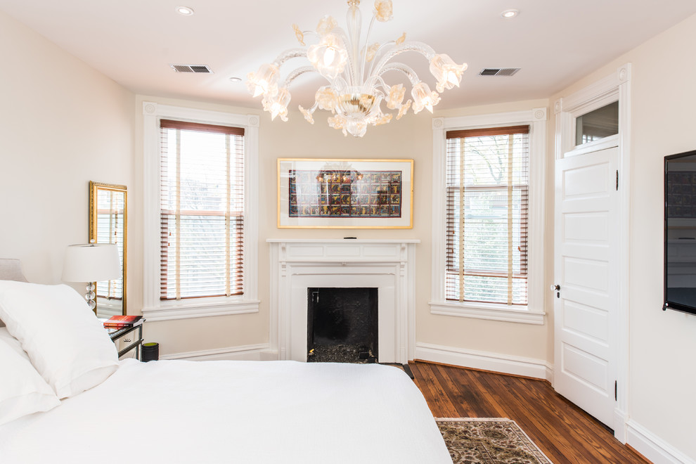 Aménagement d'une chambre d'amis victorienne de taille moyenne avec un mur beige, parquet foncé, une cheminée standard, un manteau de cheminée en bois et un sol marron.