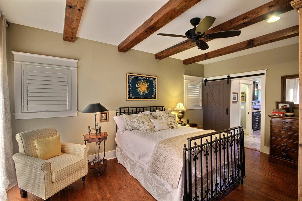 Imagen de dormitorio principal de estilo de casa de campo de tamaño medio sin chimenea con paredes beige, suelo de madera en tonos medios y suelo marrón
