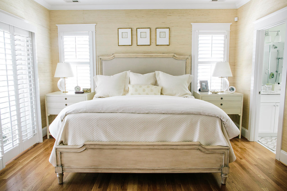 Medium sized beach style master bedroom in Houston with beige walls and medium hardwood flooring.
