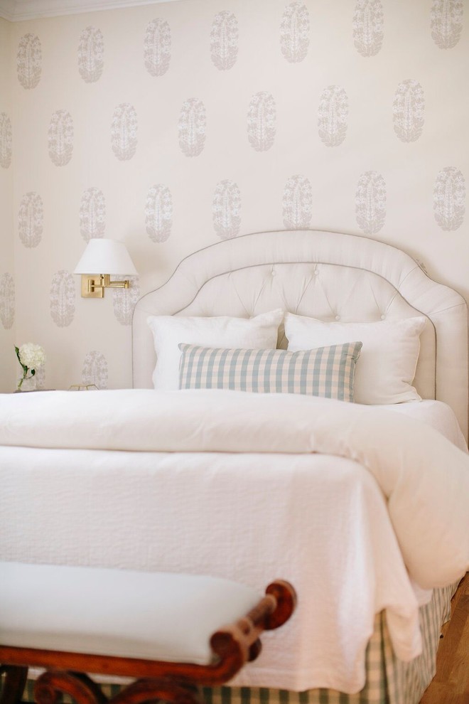 Modelo de habitación de invitados costera de tamaño medio con paredes beige y suelo de madera en tonos medios