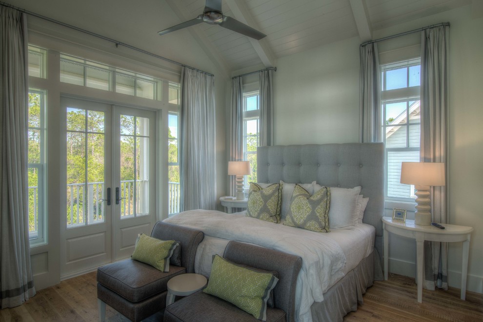 Beach style master bedroom in Miami with white walls and medium hardwood flooring.
