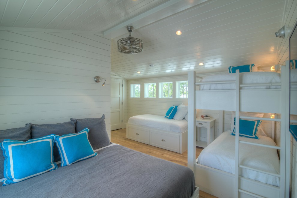 Immagine di una camera degli ospiti costiera con pareti bianche e pavimento in legno massello medio