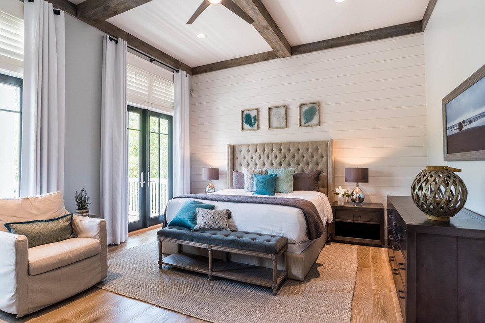 Beach style medium tone wood floor and brown floor bedroom photo in Dallas with beige walls