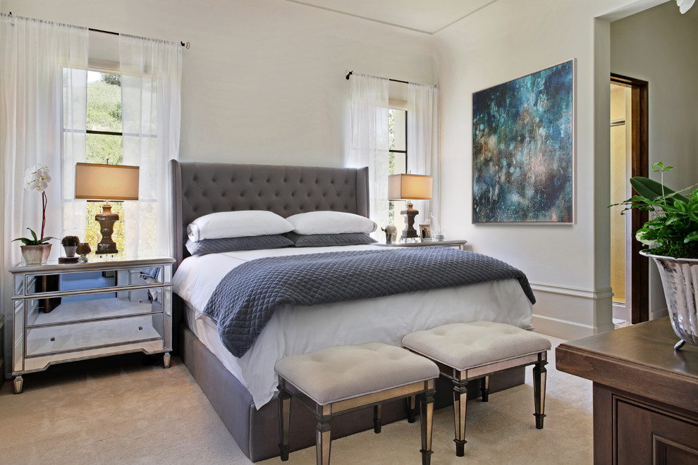 This is an example of a traditional bedroom in Orange County with white walls and carpet.
