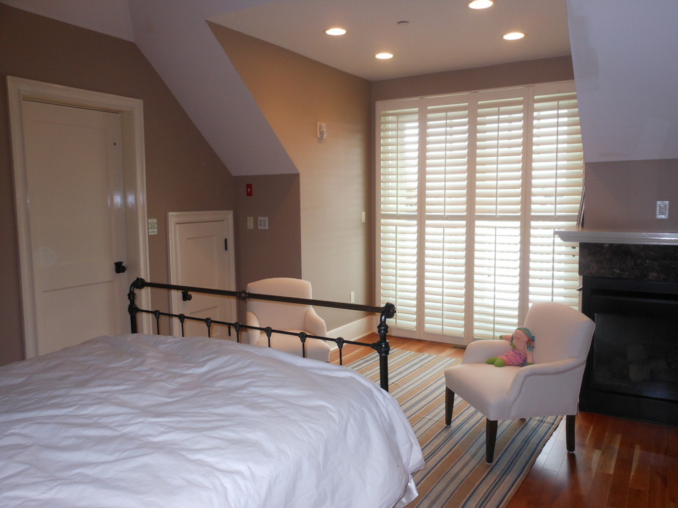 Esempio di una camera da letto stile marinaro con pareti marroni, pavimento in legno massello medio, camino ad angolo e cornice del camino in pietra