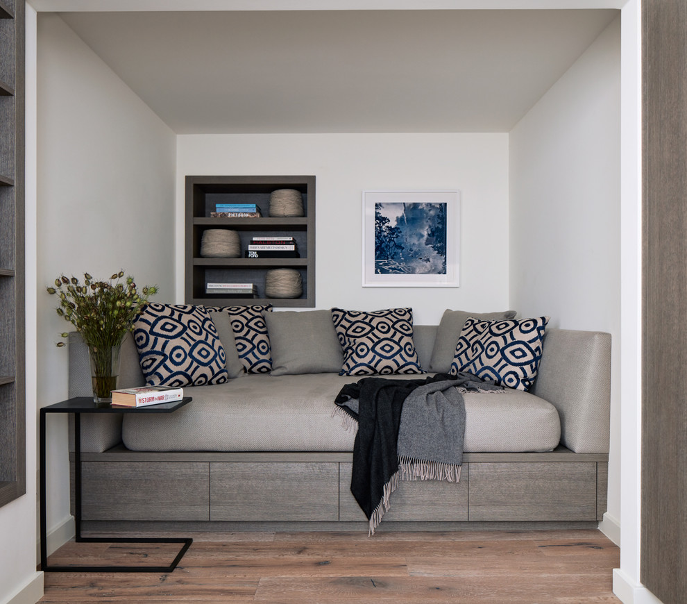 Inspiration för små moderna gästrum, med vita väggar, mellanmörkt trägolv och brunt golv