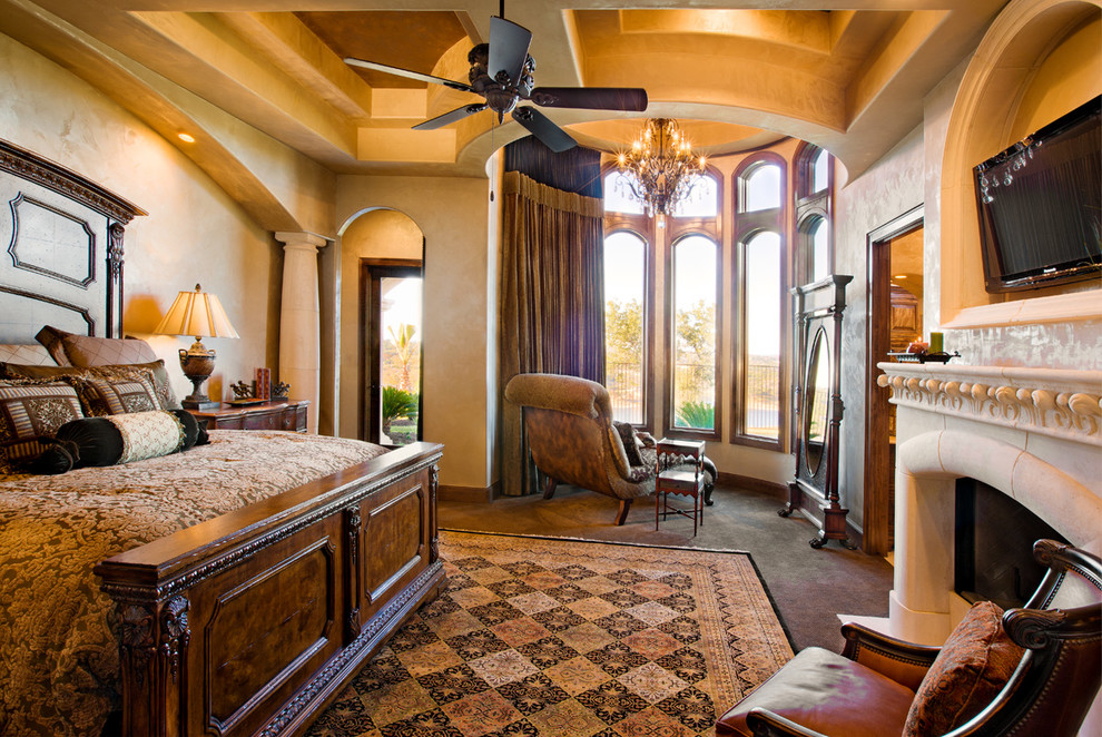 Geräumiges Mediterranes Hauptschlafzimmer mit beiger Wandfarbe, Travertin, Kamin und Kaminumrandung aus Stein in Austin