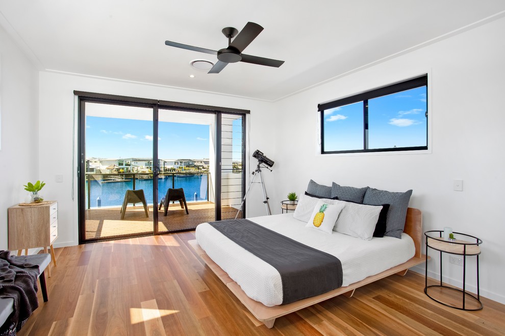 Contemporary master bedroom in Gold Coast - Tweed with white walls, medium hardwood flooring and brown floors.