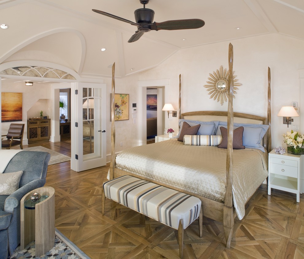 Diseño de dormitorio principal costero grande sin chimenea con paredes blancas y suelo de madera en tonos medios