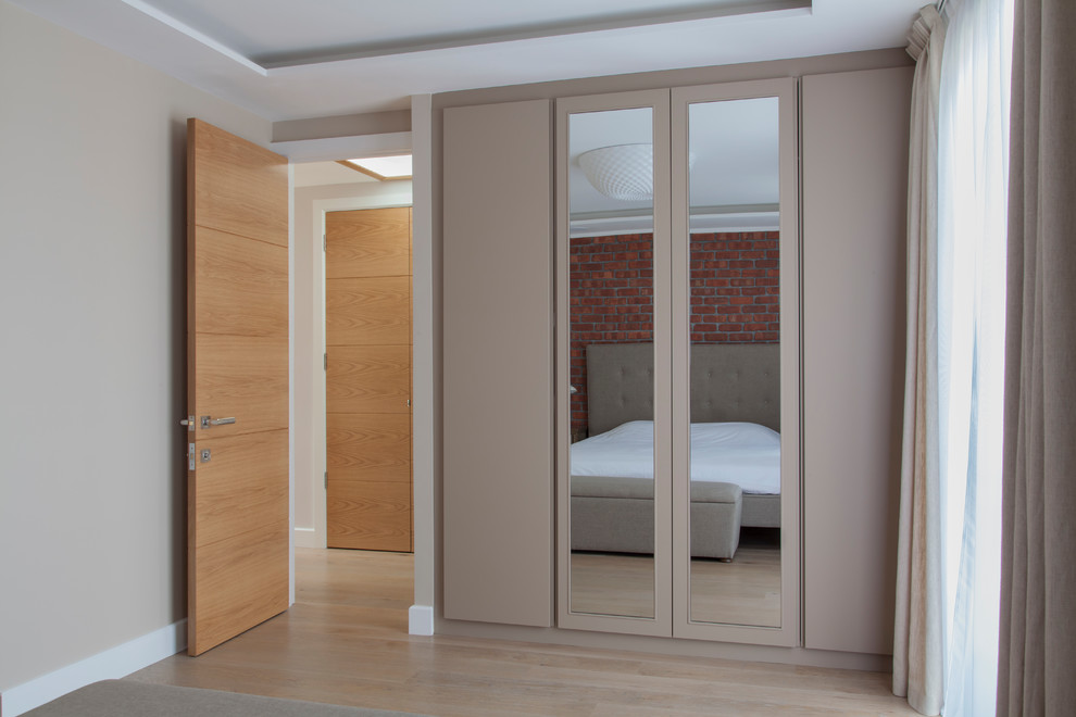 Mittelgroßes Modernes Hauptschlafzimmer mit beiger Wandfarbe, hellem Holzboden und beigem Boden in London