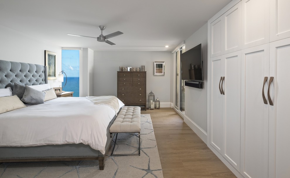 Imagen de dormitorio principal costero de tamaño medio con paredes grises, suelo de baldosas de cerámica y suelo beige