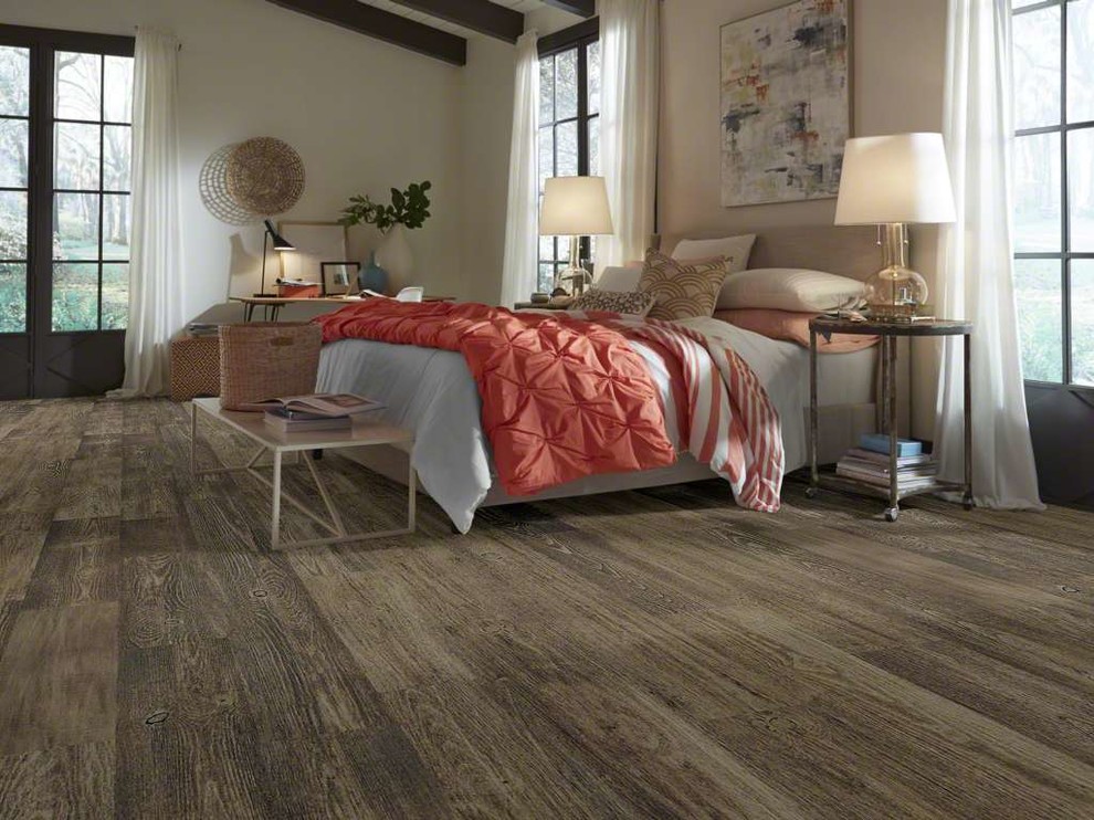 Diseño de dormitorio principal rústico grande con suelo de madera en tonos medios y suelo marrón