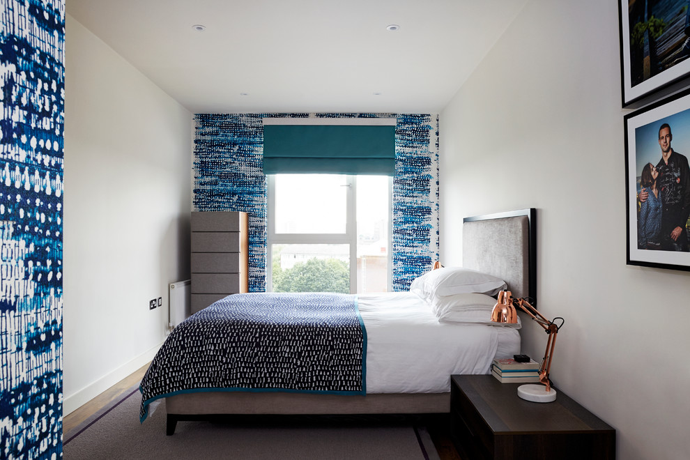 Diseño de dormitorio principal moderno de tamaño medio sin chimenea con paredes azules y suelo de madera oscura