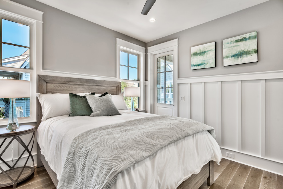 На фото: гостевая спальня среднего размера, (комната для гостей): освещение в морском стиле с серыми стенами, темным паркетным полом и коричневым полом без камина
