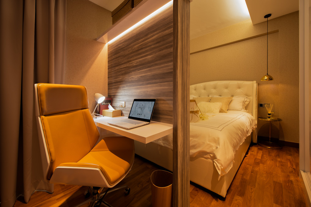 Foto di una piccola camera matrimoniale design con pareti beige e pavimento in legno massello medio