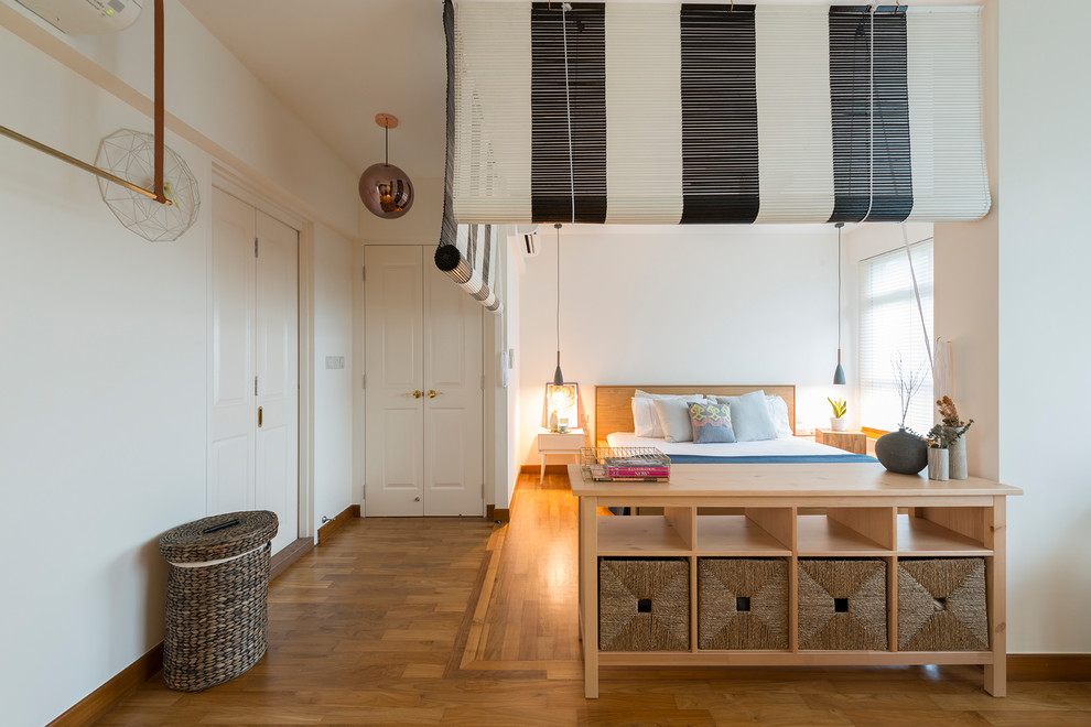 Inspiration for a traditional bedroom in Singapore with white walls and light hardwood flooring.