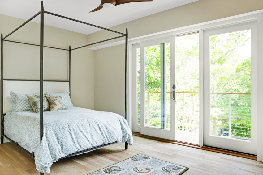 Cette photo montre une chambre d'amis moderne avec un mur beige, parquet clair, aucune cheminée et un sol marron.